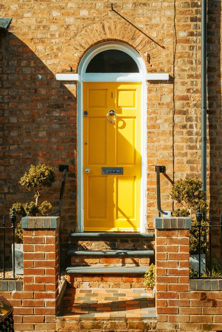 Charming British brick house with a standout yellow door